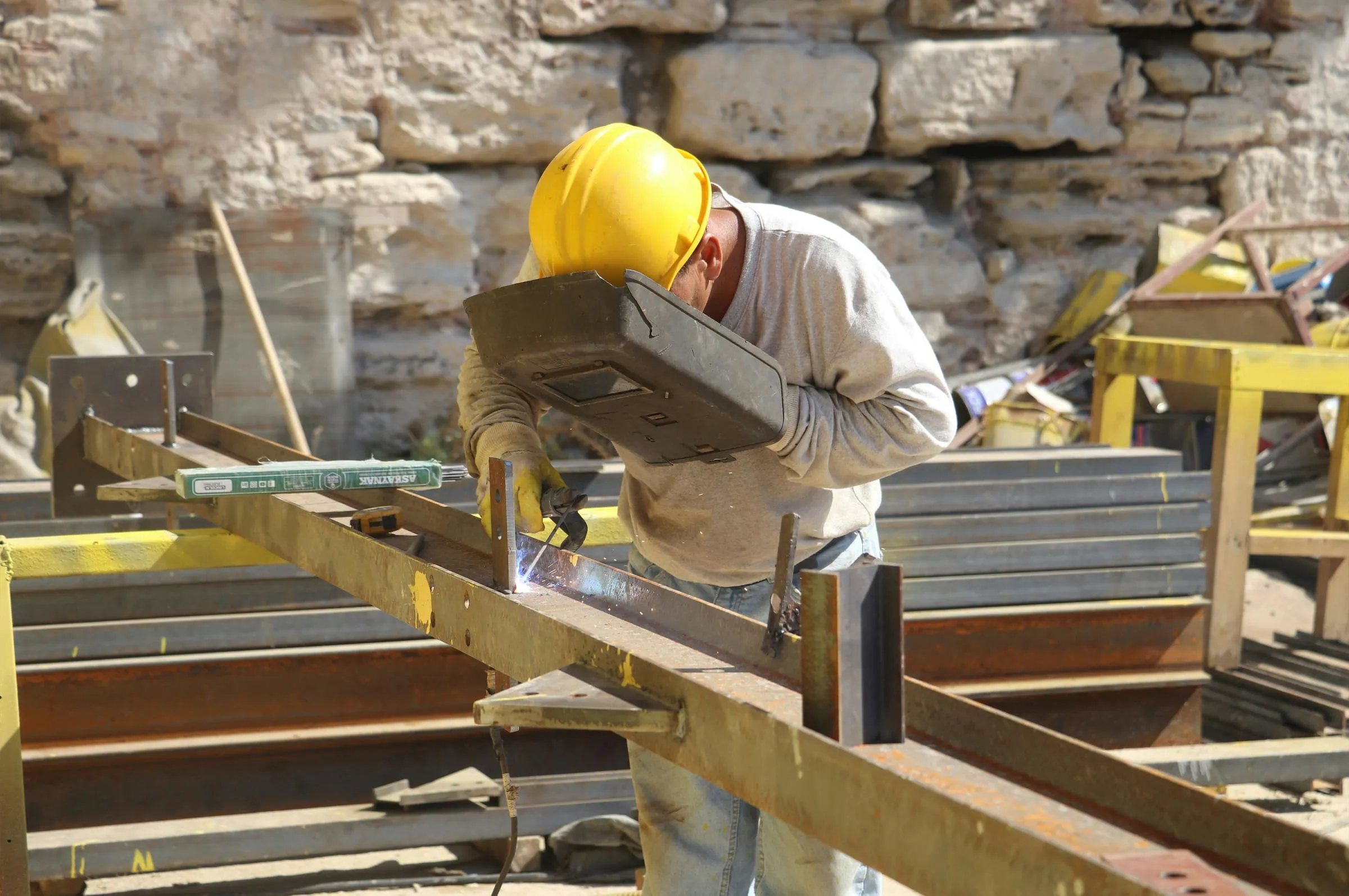 A welder working on a steel frame